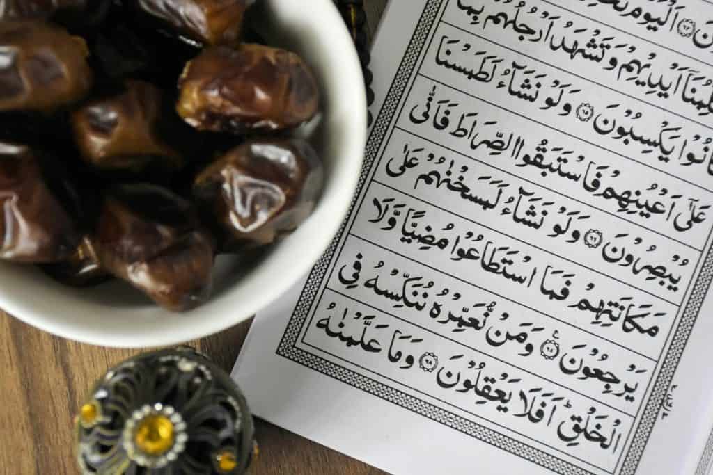 Dates and an open Quran on a table, representing Fasting During Ramadan